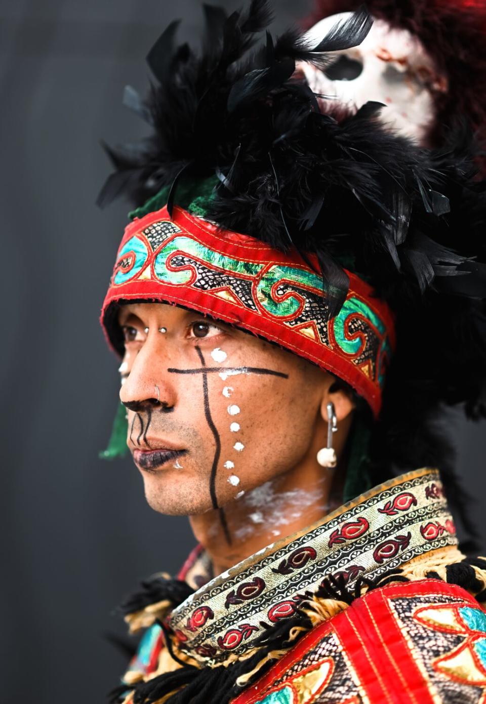 A man in a feathered headdress and face paint