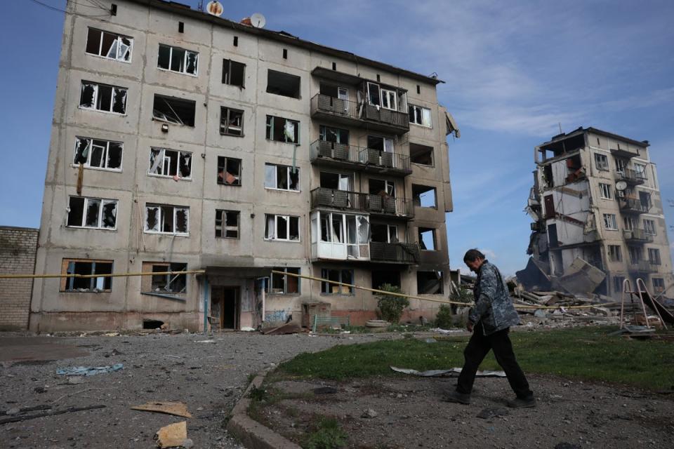 A local resident walks past apartment buildings destroyed by airstrikes in the village of Ocheretyne, days before it was taken by Russian forces (AFP via Getty)