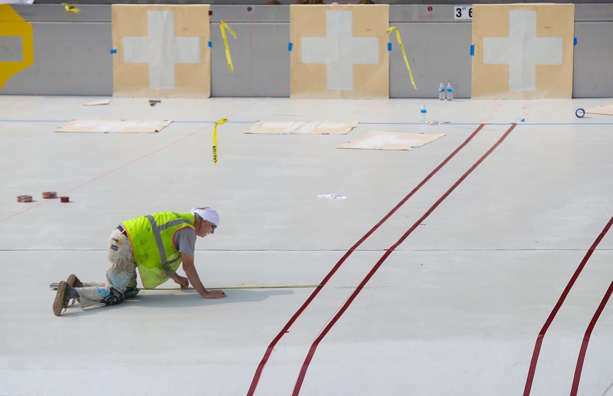 A worker maps out striping at the bottom of the Akron's new Perkins Pool project, which was funded by the American Rescue Plan Act funds.