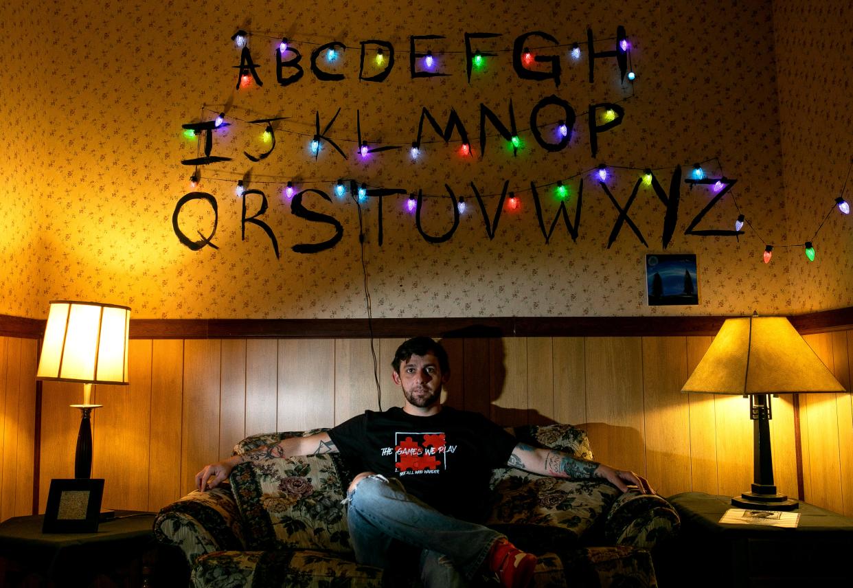 Kelly Brown, of Bremen, sits on a couch inside of the Stranger Things TV Show themed room called "The Upside Down" at The Games We Play Escape Room on June 25, 2024, in Lancaster, Ohio.