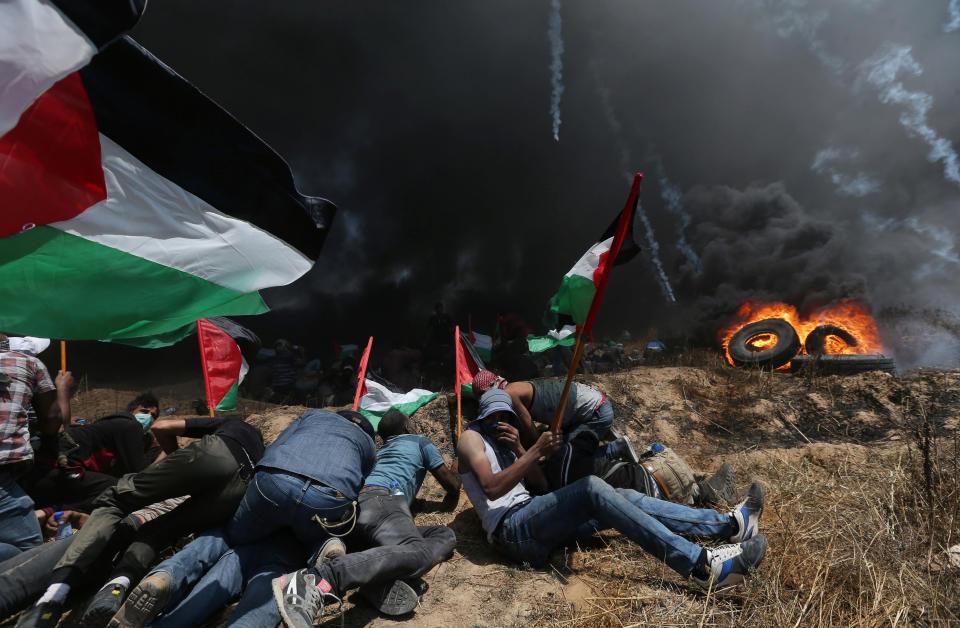 Palestinian demonstrators take cover from Israeli fire and tear gas during a protest against U.S. embassy move to Jerusalem. (Photo: Ibraheem Abu Mustafa / Reuters)