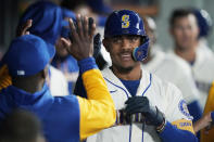 Seattle Mariners' Julio Rodriguez is greeted in the dugout after he hit a solo home run against the Oakland Athletics during the first inning of a baseball game, Sunday, July 3, 2022, in Seattle. (AP Photo/Ted S. Warren)