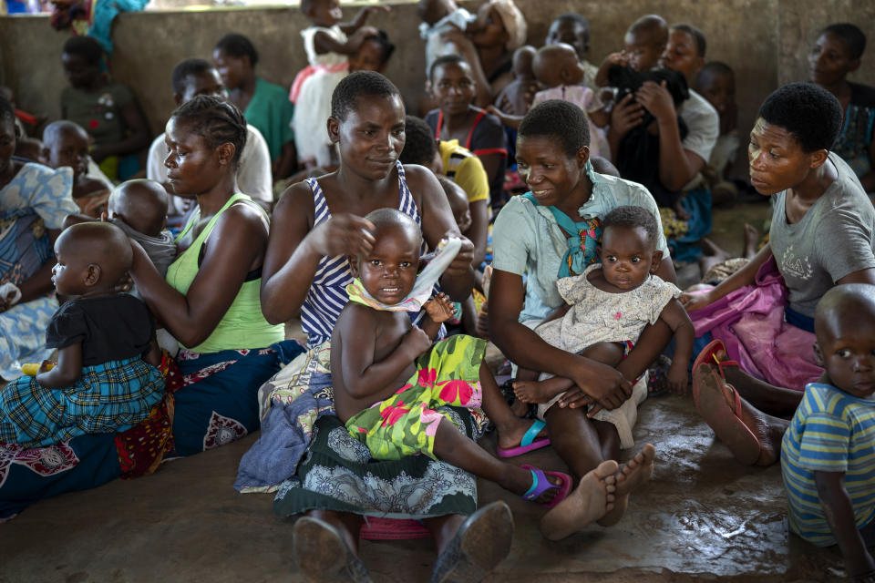 In this photo taken Wednesday, Dec. 11, 2019, residents of the Malawi village of Tomali wait to have their young children become test subjects for the world's first vaccine against malaria. Babies in three African nations are getting the first and only vaccine for malaria in a pilot program. World health officials want to see how well the vaccine works in Malawi, Ghana and Kenya before recommending its wider use. (AP Photo/Jerome Delay)