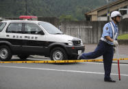 <p>A police officer walks over a police line tape in front of the gate to Tsukui Yamayuri-en, a facility for the handicapped where a number of people were killed and dozens injured in a knife attack in Sagamihara, outside Tokyo Tuesday, July 26, 2016. (AP Photo/Eugene Hoshiko)</p>