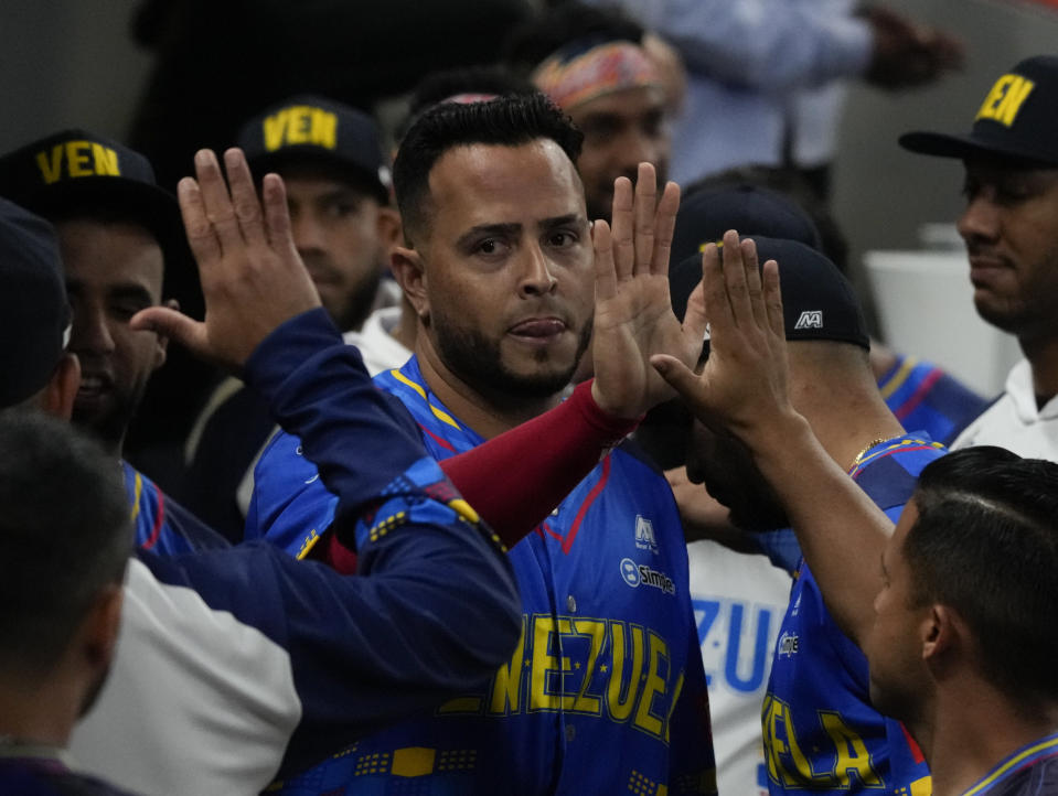 Carlos Rivero, pelotero de cuadro de los Leones del Caracas, es felicitado por sus compañeros luego de anotar ante los Federales de Chiriquí, en la Serie del CAribe, el jueves 2 de febrero de 2023 (AP Foto/Fernando Llano)