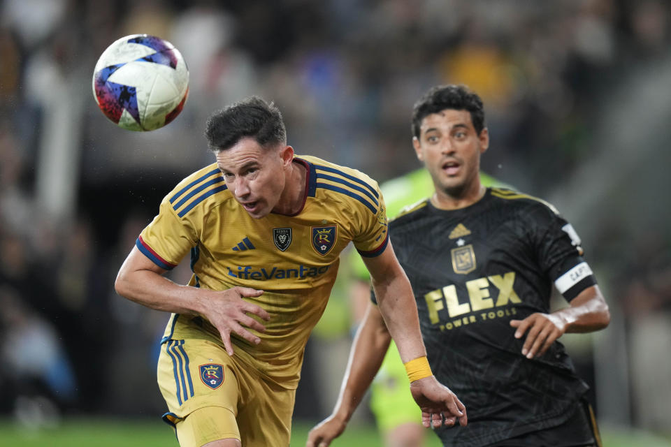 Real Salt Lake defender Bryan Oviedo, left, heads the ball as he is chased by Los Angeles FC forward Carlos Vela, right, during the second half of an MLS soccer match Sunday, Oct. 1, 2023, in Los Angeles. (AP Photo/Jae C. Hong)