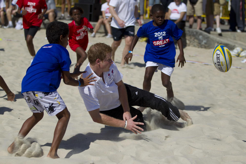 Britain's Prince Harry plays rugby at Flamengo's beach in Rio de Janeiro, Brazil, Saturday March 10, 2012. Harry is in Brazil at the request of the British government on a trip to promote ties and emphasize the transition from the upcoming 2012 London Games to the 2016 Olympics in Rio de Janeiro. The prince began Saturday teaching tag-rugby to children and taking beach volleyball lessons. (AP Photo/Felipe Dana)