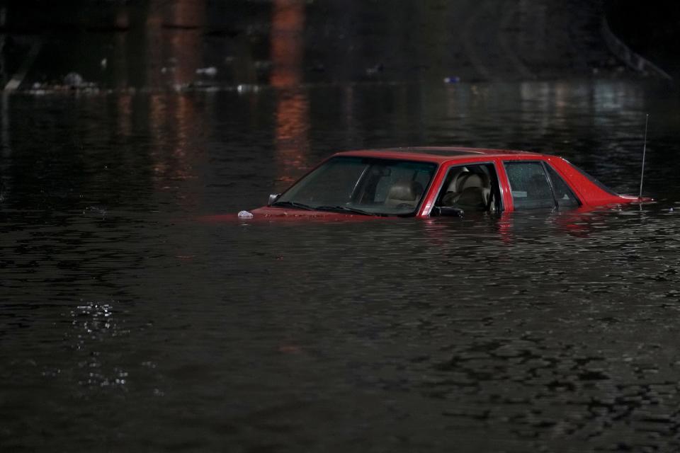 A car submerged up to the windows in a flooded street