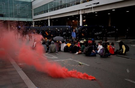 Protesters sit as they demonstrate at the airport, after a verdict in a trial over a banned independence referendum, in Barcelona