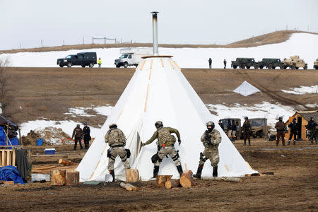 Law enforcement officers cut open a shelter in the main opposition camp against the Dakota Access oil pipeline near Cannon Ball, North Dakota, U.S., February 23, 2017. REUTERS/Terray Sylvester