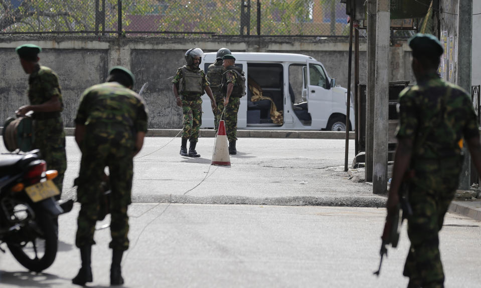 Sri Lankan security forces officers inspect a suspicious vehicle parked near St. Anthony's shrine before it exploded in Colombo, Sri Lanka, Monday, April 22, 2019. Easter Sunday bombings that ripped through churches and luxury hotels killed more than 200 people. (AP Photo/Eranga Jayawardena)