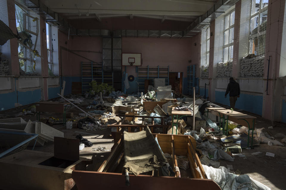 A man walks through a sports gym in School No. 2 which was used as a base and field hospital for Russian soldiers in the recently retaken town of Izium, Ukraine, Wednesday, Sept. 21, 2022. Based on accounts of survivors and police, Associated Press journalists located 10 torture sites in the town and gained access to five of them, including the school. (AP Photo/Evgeniy Maloletka)