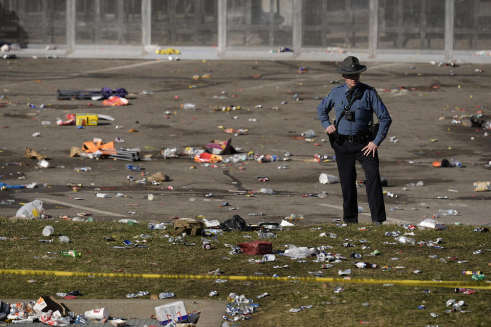 FILE - A law enforcement officer stands amid debris as he looks around the scene following a shooting at the Kansas City Chiefs NFL football Super Bowl celebration in Kansas City, Mo., Wednesday, Feb. 14, 2024. (AP Photo/Charlie Riedel, File)