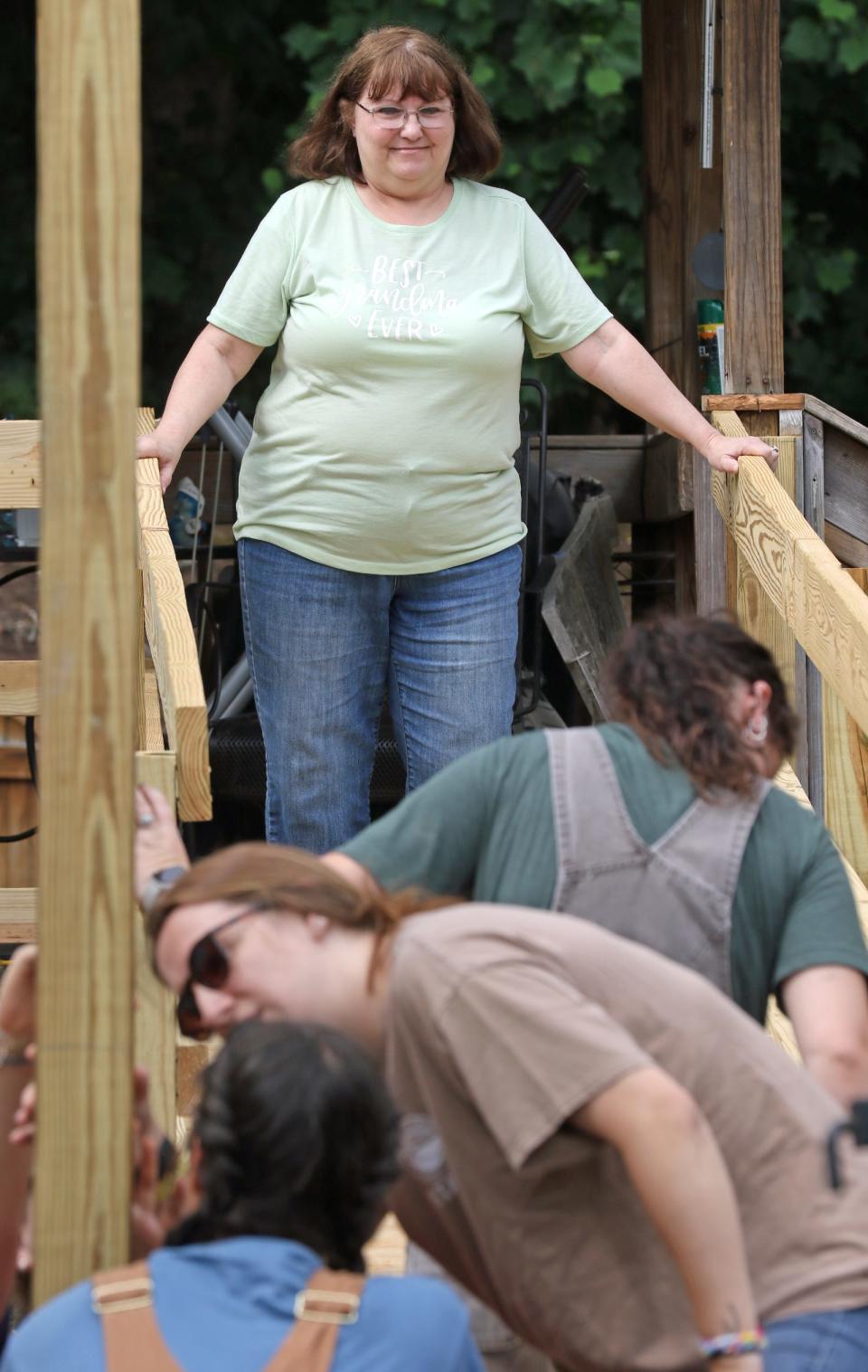 Homeowner Cindy Fisher watches as members of Carolina Cross work to build a ramp outside her home on Fluffy Lane near Bessemer City Friday morning, June 24, 2022.