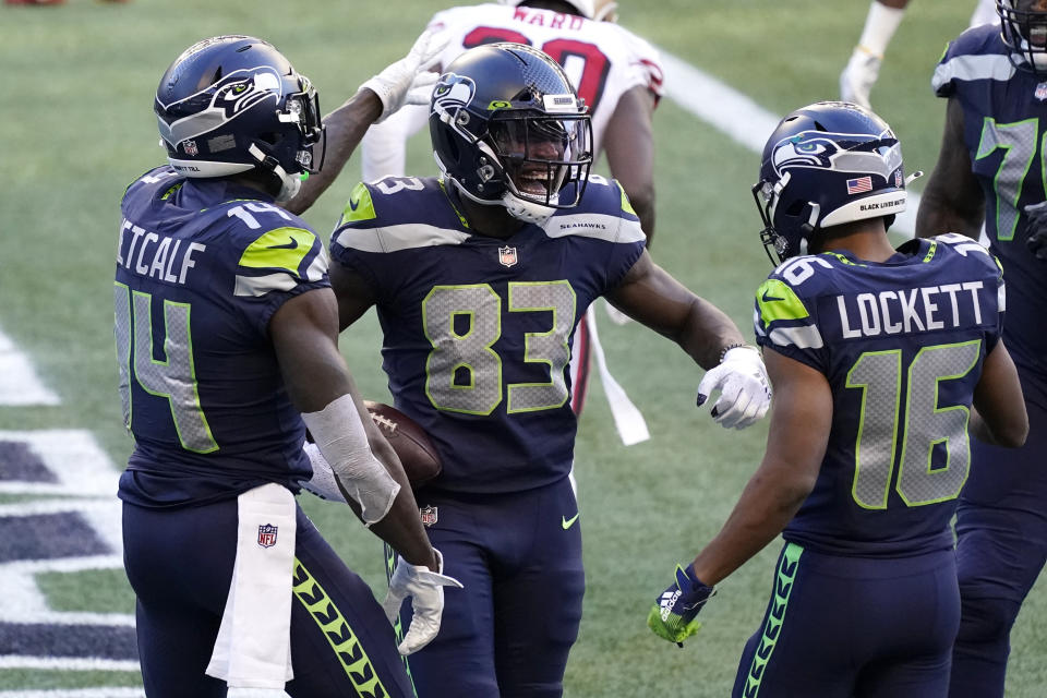 Seattle Seahawks wide receiver David Moore (83) celebrates with DK Metcalf, left, and Tyler Lockett (16), after Moore scored a touchdown against the San Francisco 49ers during the second half of an NFL football game, Sunday, Nov. 1, 2020, in Seattle. (AP Photo/Elaine Thompson)