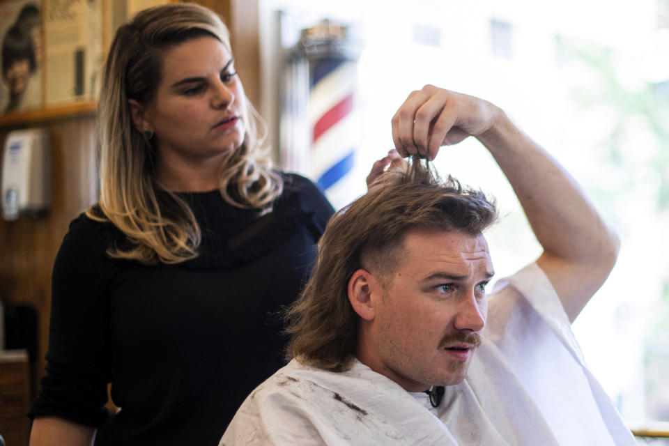 Country singer Morgan Wallen receives a mullet at Paul Mole Barber Shop on Tuesday, Aug. 27, 2019, in New York. Wallen, who has turned heads with his likable hit song “Whiskey Glasses," said he decided to try a mullet after seeing old photos of his dad proudly rocking the hairstyle. (Photo by Charles Sykes/Invision/AP)