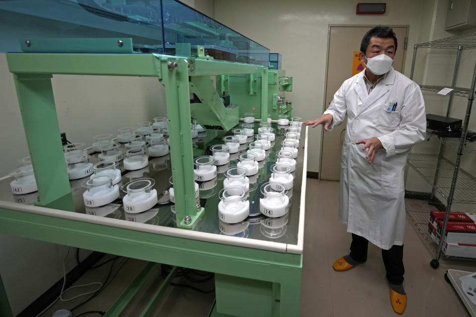 University of Tokyo radiologist Katsumi Shozugawa explains a machine to analyze contamination level in his laboratory at the university in Tokyo on Feb. 16, 2023. Shozugawa said his analysis of groundwater in multiple locations in no-go zones near the plant has shown that tritium and other radioactive elements have been leaking into groundwater. (AP Photo/Shuji Kajiyama)