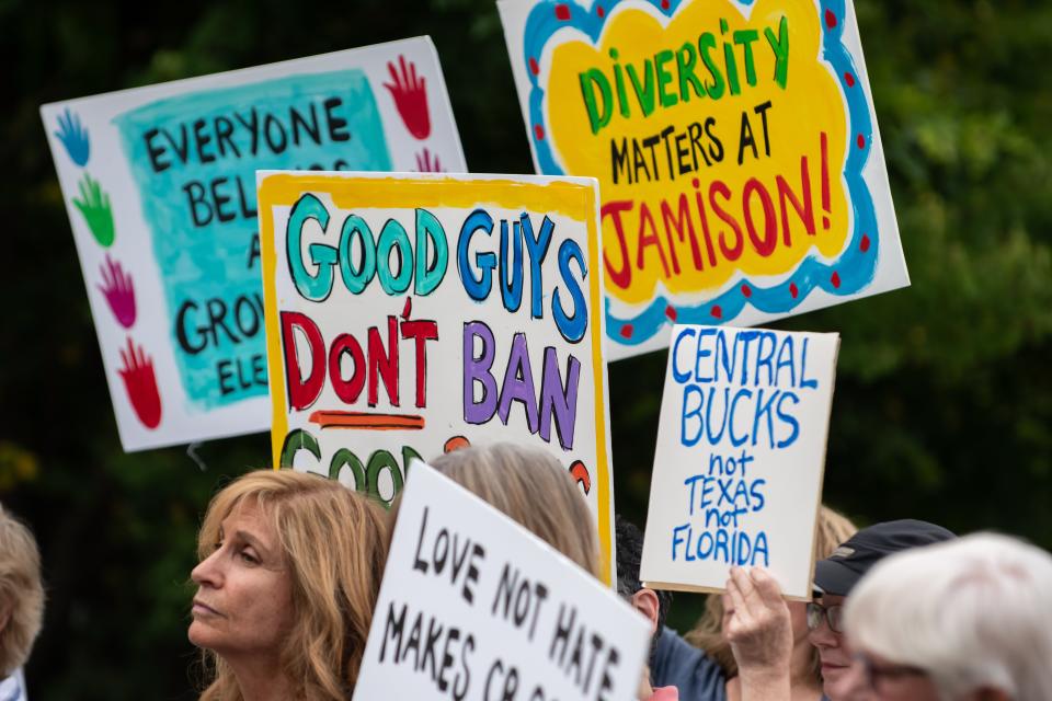 Opponents to a proposed library policy in the Central Bucks School District stood outside prior to a school board meeting on Tuesday, Jully 26, 2022, holding up signs comparing the policy to censorship and book banning.