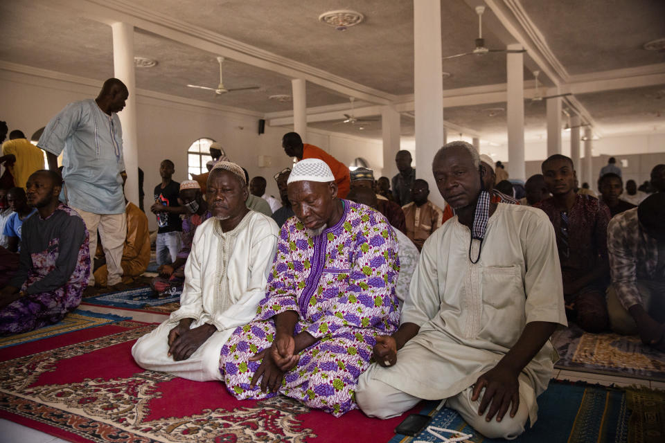 Muslim worshippers participate in Friday prayers at the Sangoulé Lamizana military camp in Ouagadougou, Burkina Faso, Friday April 9, 2021. Just seven chaplains, hailing from Protestant, Catholic and Muslim faiths, are charged with spiritually advising some 11,000 soldiers and helping maintain their morale. (AP Photo/Sophie Garcia)