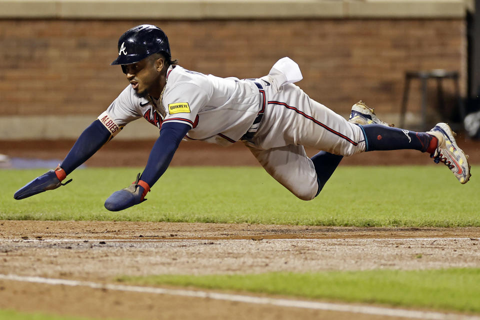 Atlanta Braves' Ozzie Albies scores after New York Mets' Tim Locastro was charged with a fielding error during the eighth inning in the second baseball game of a doubleheader Saturday, Aug. 12, 2023, in New York. (AP Photo/Adam Hunger)