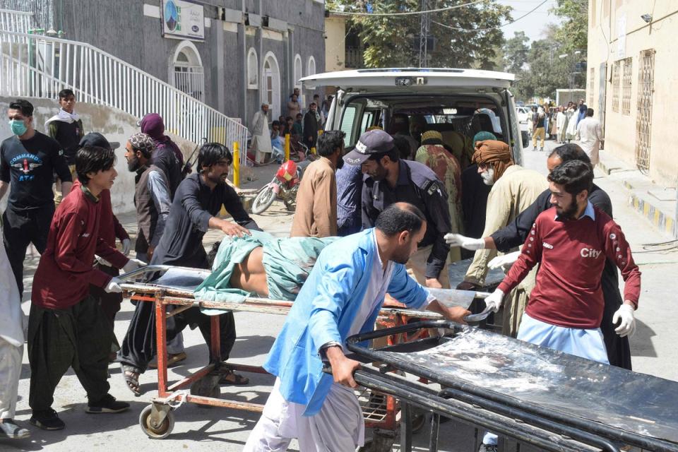 Volunteers carry a blast victim on a stretcher at a hospital in Quetta (AFP via Getty Images)