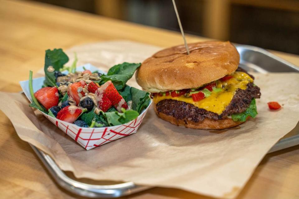 The Andalucia burger at Barcelona Burger and Beer Garden at Merino Mill has American cheese, avocado, peppadew peppers, lettuce, onion and salsa verde. The side is a Blue Salad with spring mix, blue cheese, candied pecans, blueberries and apricot dressing.