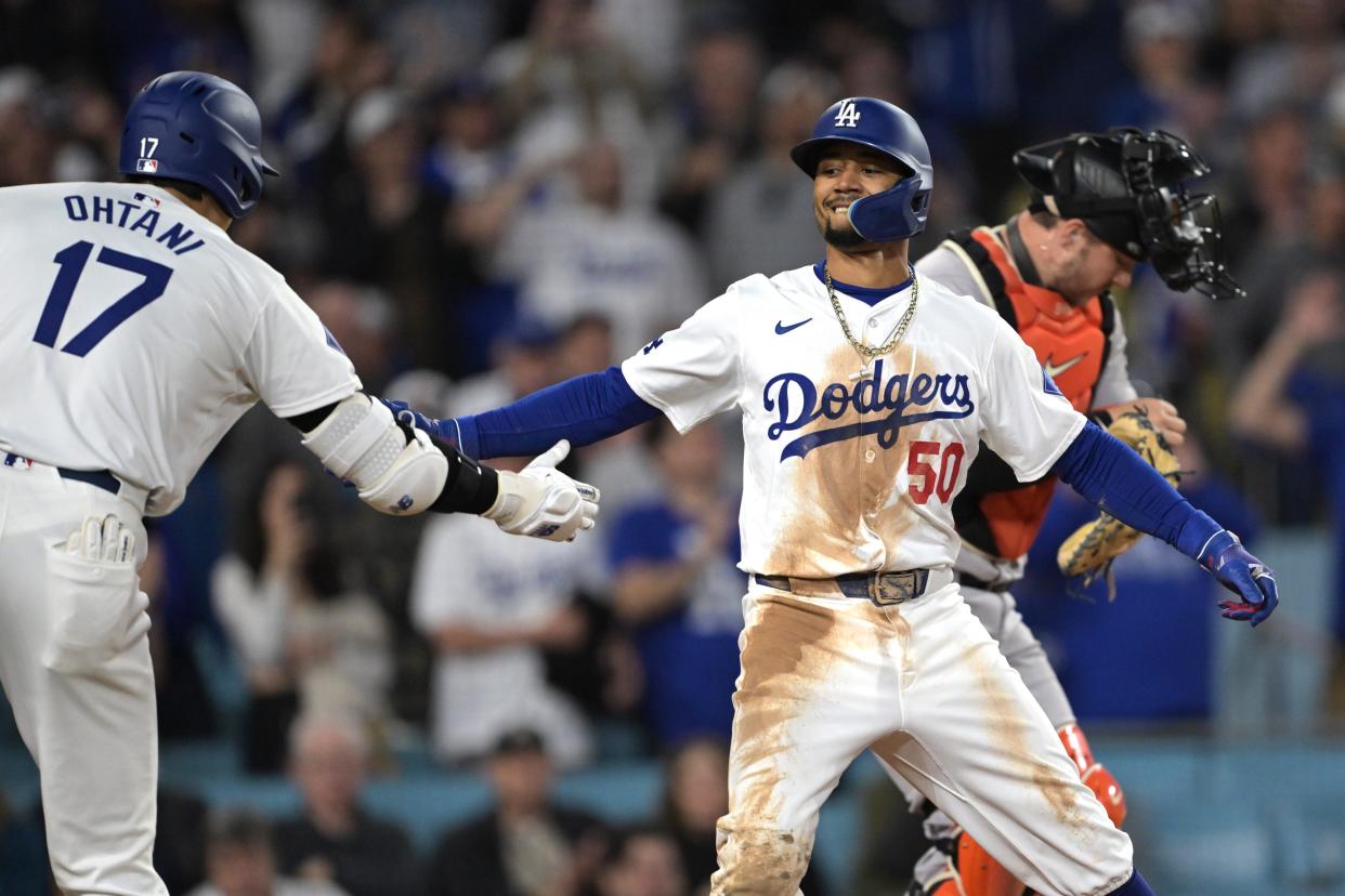Los Angeles Dodgers shortstop Mookie Betts (50) is congratulated by designated hitter Shohei Ohtani (17) after hitting a solo home run for his 1500th career hit in the third inning against the San Francisco Giants at Dodger Stadium.