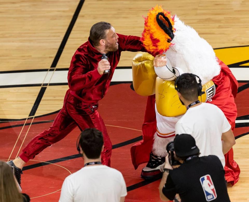 Mixed martial arts fighter Conor McGregor swings at Miami Heat mascot Burnie as part of a skit during a timeout period in Game 4 of the NBA Finals between the Miami Heat and the Denver Nuggets at the Kaseya Center on Friday, June 9, 2023, in downtown Miami, Fla. The man in the mascot suit had to be taken to the hospital after he was hit.