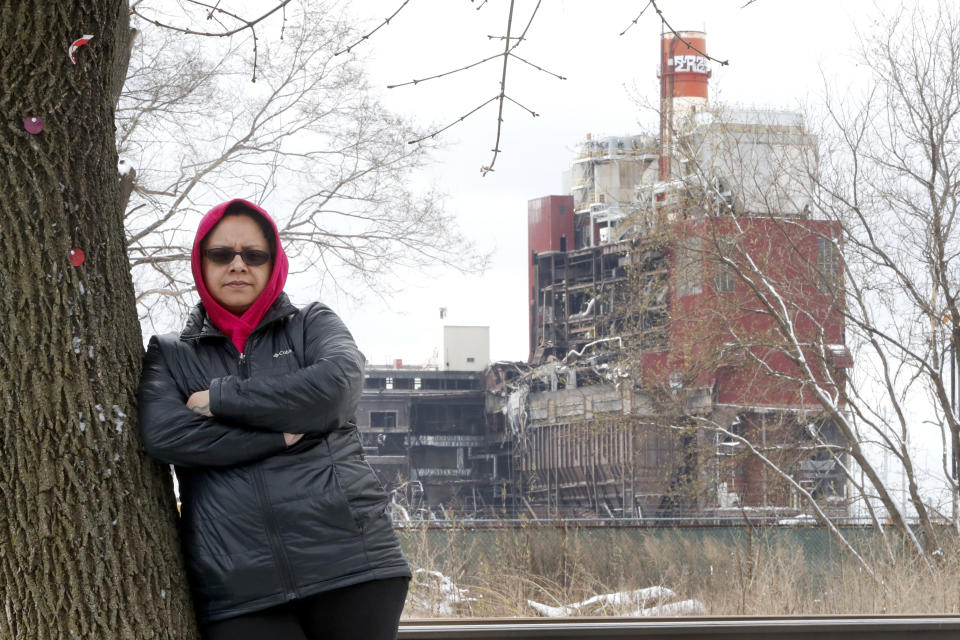 In this Wednesday, April 15, 2020, photo, Kim Wasserman with the Little Village Environmental Justice Organization in Chicago, poses near the Crawford Coal Plant, the last of the city's coal power plants, where demolition is ongoing. Demolition of an old smokestack at a former coal-fired power plant recently sent a cloud of ash into the neighborhood. The low-income, Hispanic community also is concerned that plans for a logistics and transportation hub will bring more diesel pollution to the neighborhood. Communities of color are still disproportionately affected by pollution 50 years after the first Earth Day. (AP Photo/Charles Rex Arbogast)