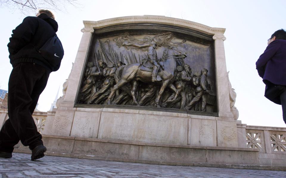 FILE - In this March 26, 2011, file photo, people walk past the memorial to Union Col. Robert Gould Shaw and the 54th Massachusetts Volunteer Infantry Regiment, near the Statehouse in Boston. Amid the national reckoning on racism in July 2020, the memorial to the first Black regiment of the Union Army, the Civil War unit popularized in the movie "Glory," is facing scrutiny. (AP Photo/Michael Dwyer, File)