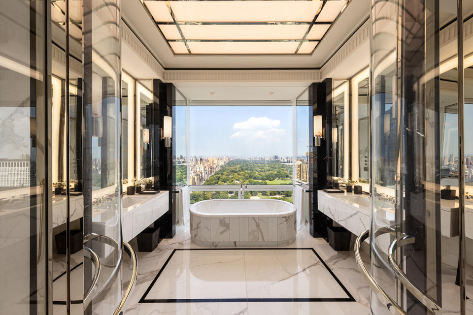 The marble-encased tub in the primary bath is set against a picture window with Central Park as the backdrop.