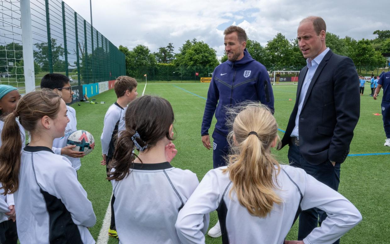 Children speak to the Prince and Harry Kane as they take part in friendly matches