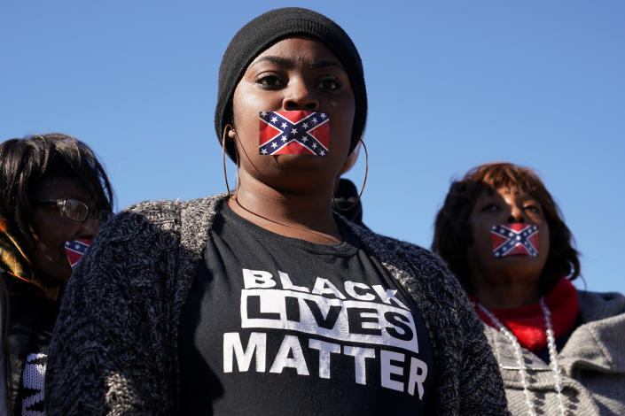 <p>People stand in silent protest with confederate flag stickers covering their mouths during the official opening ceremony for the Mississippi Civil Rights Museum in Jackson, Miss., Dec. 9, 2017. (Photo: Carlo Allegri/Reuters) </p>