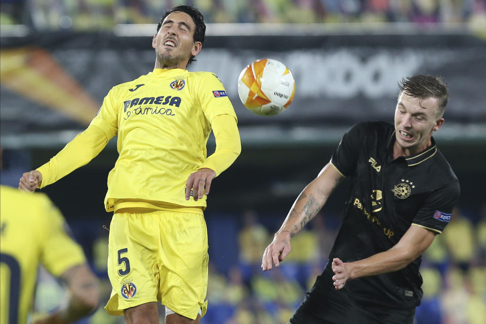 FILE - Maccabi Tel-Aviv's Eden Karzev, right, heads for the ball with Villareal's Dani Parejo during a Europa League Group I soccer match between Villarreal and Maccabi Tel-Aviv at the Ceramica stadium in Villarreal, Spain, Thursday, Nov. 5, 2020. Turkish top-flight soccer club Basaksehir announced Thursday that it was parting ways with its Israeli player, Eden Karzev, following a disciplinary probe launched into a social media post that called for the release of hostages held by the Hamas militant group. (AP Photo/Alberto Saiz, File)