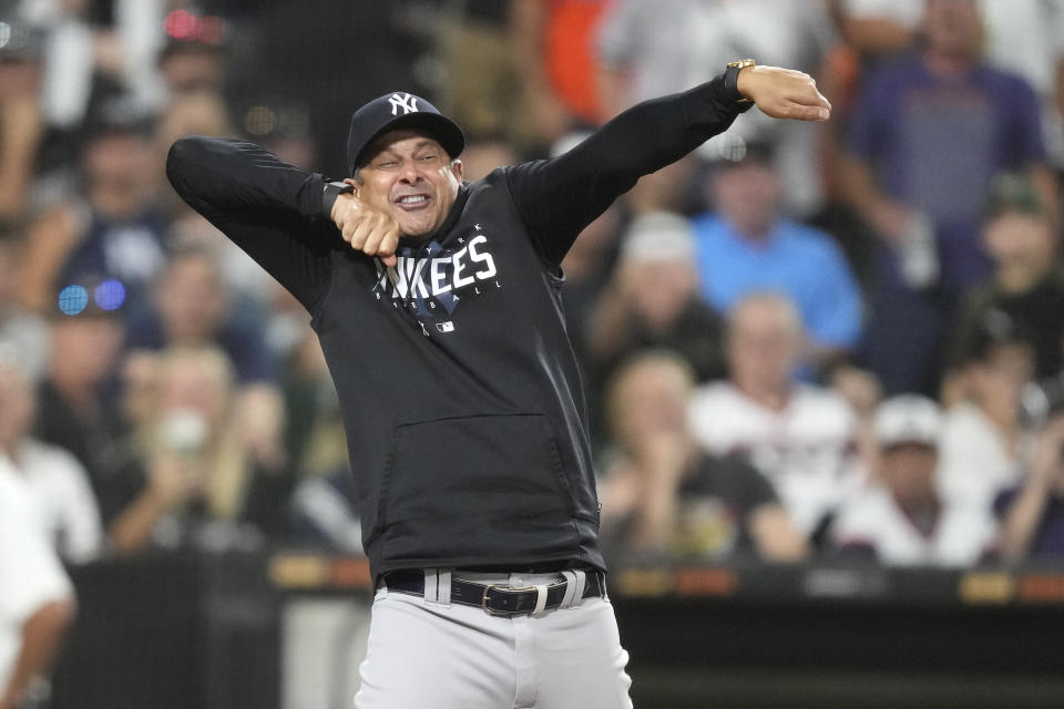 New York Yankees manager Aaron Boone imitates an umpire calling strike three after arguing with home plate umpire Laz Diaz during the eighth inning of a baseball game against the Chicago White Sox Monday, Aug. 7, 2023, in Chicago. (AP Photo/Charles Rex Arbogast)