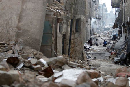 People work in a damaged neighborhood in Aleppo. REUTERS/Omar Sanadiki