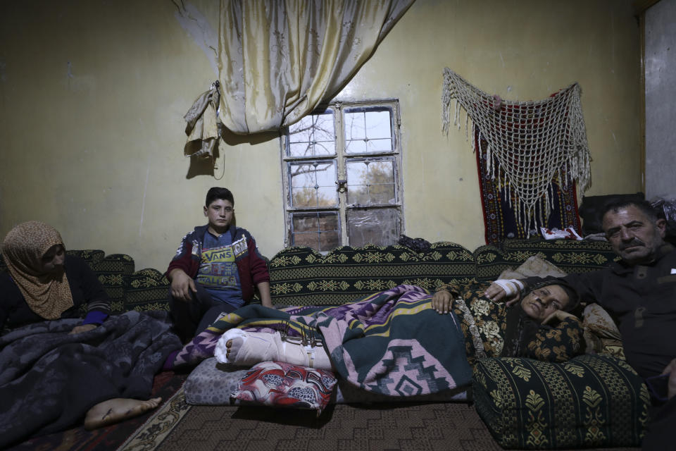 Ahmad Qassim, sits with his wife who were both injured in an US airstrike, at their home in the village of al-Rami in Idlib province, Syria, Monday, Dec. 6, 20201. A U.S. airstrike targeting an al-Qaida leader in northern Syria has wounded six of of Qassim family. The U.S. military say it conducted a strike from a remotely-piloted MQ-9 aircraft Friday near the city of Idlib targeting "a senior al-Qaeda leader and planner." (AP Photo/Ghaith Alsayed)