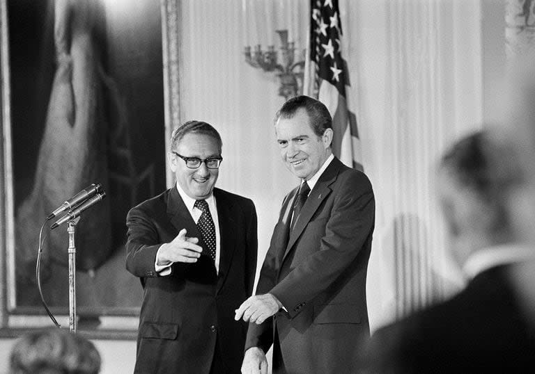 ARCHIVO - El Secretario de Estado Henry Kissinger, izquierda, hace un gesto a la audiencia en el Salón Este de la Casa Blanca, el 22 de septiembre de 1973, mientras el presidente Richard Nixon observa, en Washington (AP)