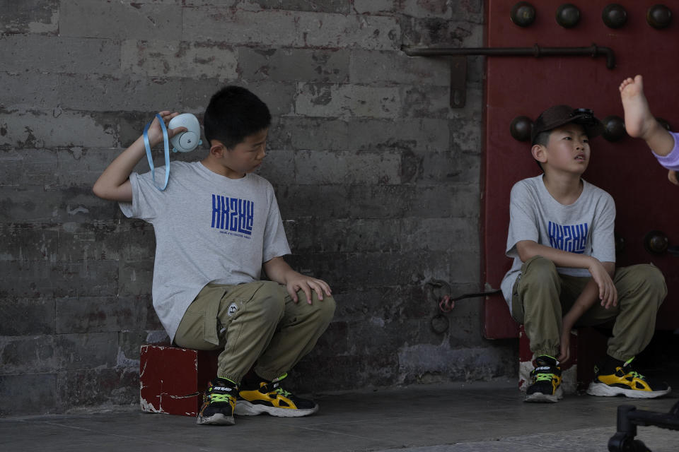 A boy cools himself with an electric fan near the Forbidden City on a sweltering day in Beijing, Friday, July 7, 2023. Earth's average temperature set a new unofficial record high on Thursday, the third such milestone in a week that already rated as the hottest on record. (AP Photo/Andy Wong)