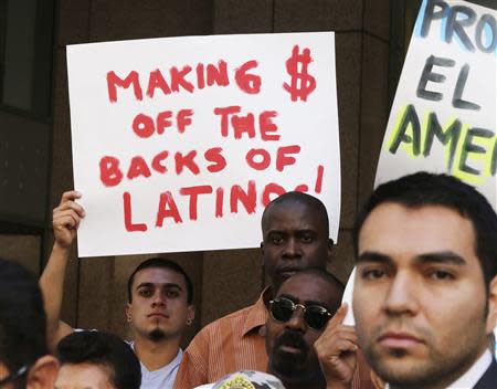 Demonstrators protesting against Herbalife, a nutrition and supplements company, hold signs outside the Ronald Reagan State Office building in Los Angeles, California October 18, 2013. According to the protestors, they are seeking action against Herbalife's business practices. REUTERS/Fred Prouser