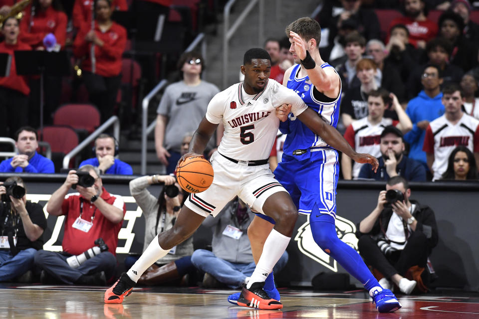 Louisville forward Brandon Huntley-Hatfield (5) attempts to get through the defense of Duke center Kyle Filipowski during the first half of an NCAA college basketball game in Louisville, Ky., Tuesday, Jan. 23, 2024. (AP Photo/Timothy D. Easley)