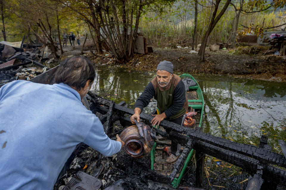 Kashmiris salvage items after a fire gutted several houseboats early morning in the interiors of Dal Lake, on the outskirts of Srinagar, Indian controlled Kashmir, Saturday, Nov. 11, 2023. A massive fire engulfed some wooden houseboats on Saturday and three charred bodies were recovered from the wreckage, officials said. (AP Photo/Dar Yasin)