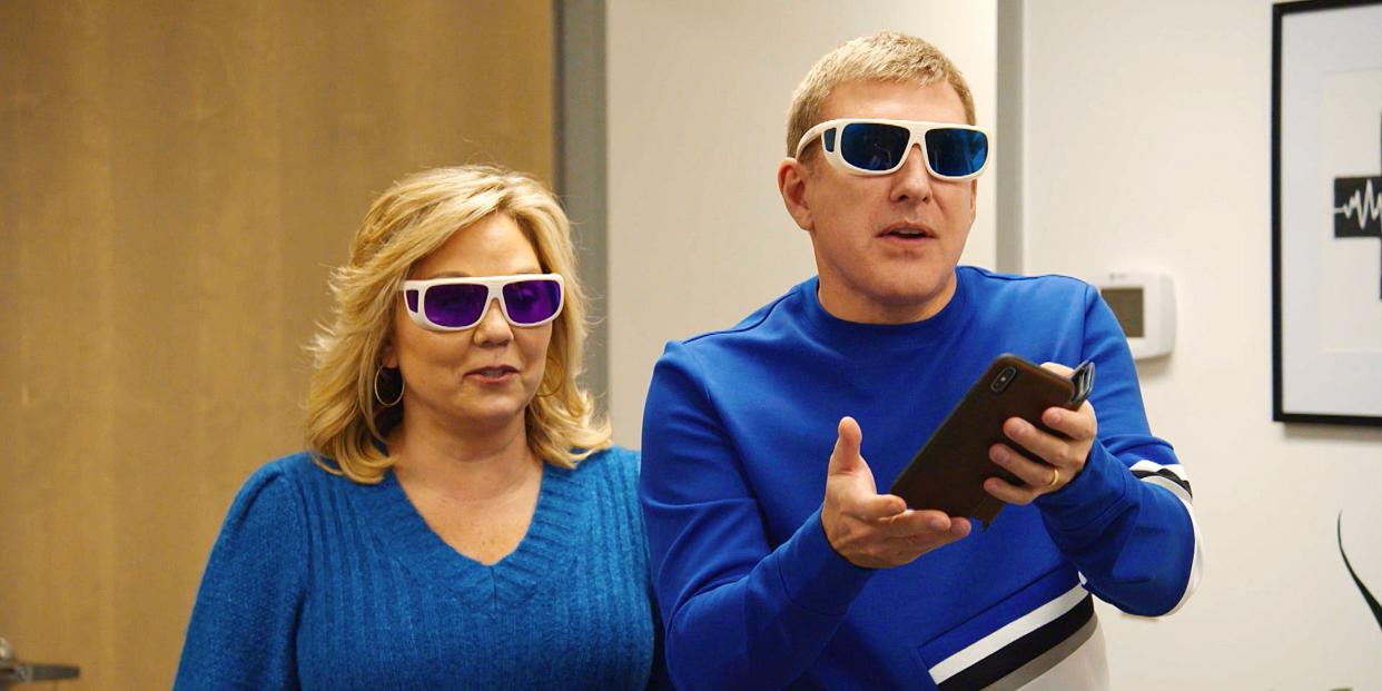 Todd and Julie Chrisley wear sunglasses and blue sweaters.