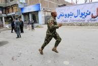 An Afghan security force personnel runs at the site of a suicide attack in Jalalabad April 18, 2015. (REUTERS/Parwiz)