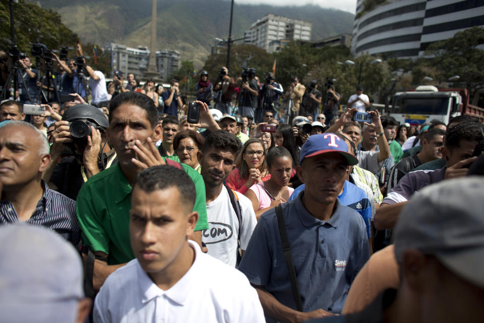 La gente escucha al autoproclamado presidente interino Juan Guiadó, quien se dirige a los trabajadores del transporte durante una manifestación de apoyo en Caracas, Venezuela, el miércoles 20 de febrero de 2019. (AP Foto / Ariana Cubillos)