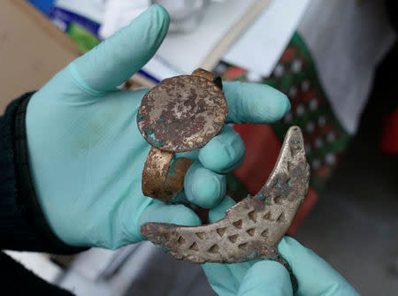 An archeologist shows metal pieces as part of an archeological finding, dated approximately 500 years ago, in Mazo Cruz, near Viacha, Bolivia, November 12, 2018. Picture taken November 12, 2018.REUTERS/David Mercado