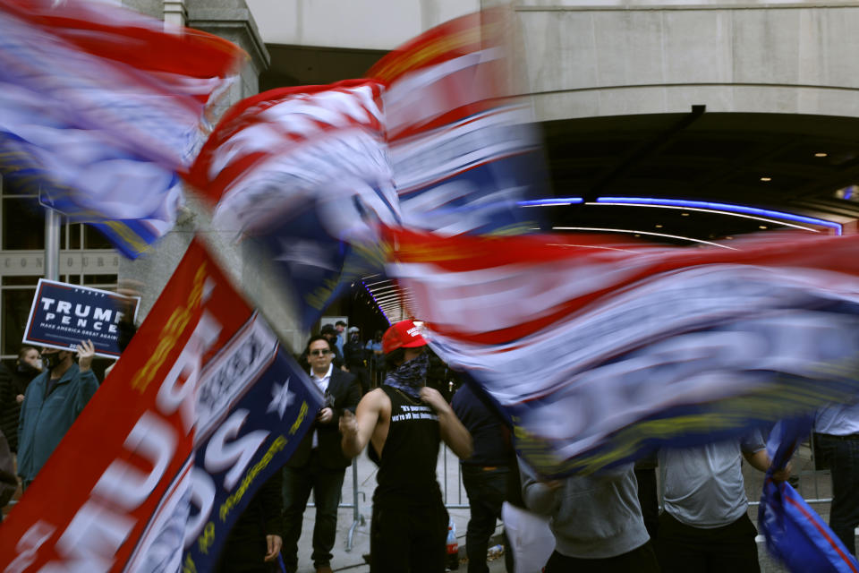 Supporters of President Donald Trump wave flags outside the Pennsylvania Convention Center where votes are being counted, Thursday, Nov. 5, 2020, in Philadelphia, following Tuesday's election. (AP Photo/Rebecca Blackwell)