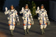 Chinese astronauts, from left, Tang Hongbo, Nie Haisheng, and Liu Boming wave as they prepare to board for liftoff at the Jiuquan Satellite Launch Center in Jiuquan in northwestern China, Thursday, June 17, 2021. China plans on Thursday to launch three astronauts onboard the Shenzhou-12 spaceship who will be the first crew members to live on China's new orbiting space station Tianhe, or Heavenly Harmony. (AP Photo/Ng Han Guan)