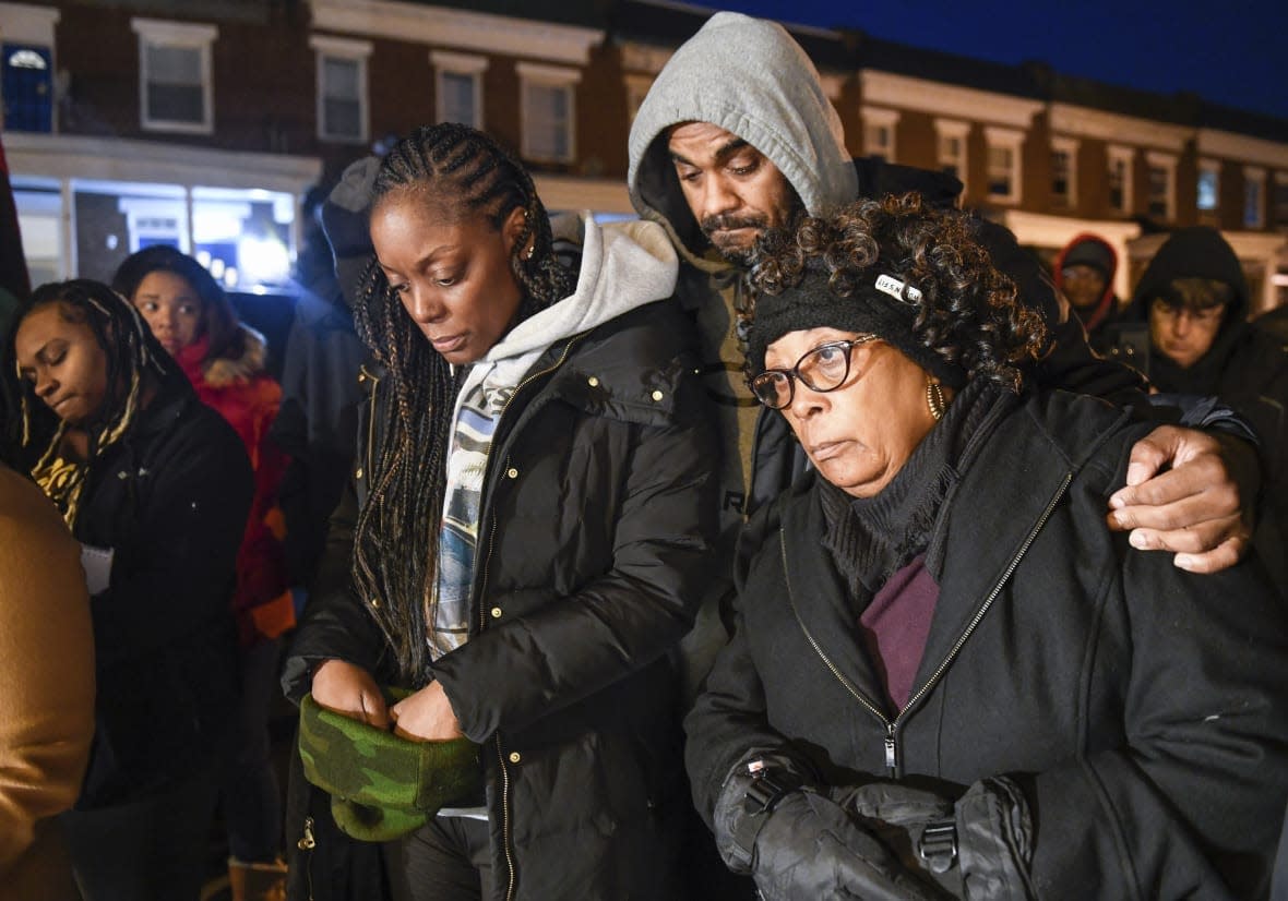 Tammy Chance, left, mother of Jalil George, 24, who was killed Dec. 7, 2022 in Baltimore, stands with George’s stepfather, Shawn Chance, center, and George’s grandmother Susie Squire, during a vigil for George on Wednesday, Dec. 14, 2022, in Baltimore. (AP Photo/Steve Ruark)