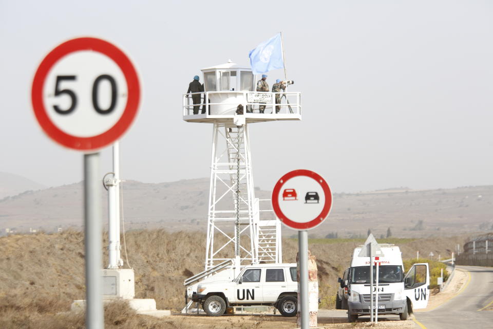 UN officers watch from an observation tower as UN vehicle enters Syria in Quneitra crossing in the Israeli controlled Golan Heights , Monday, Oct. 15, 2018. The crossing between Syria and the Israeli-occupied Golan Heights reopened for U.N. observers who had left the area four years ago because of the fighting there. (AP Photo/Ariel Schalit)